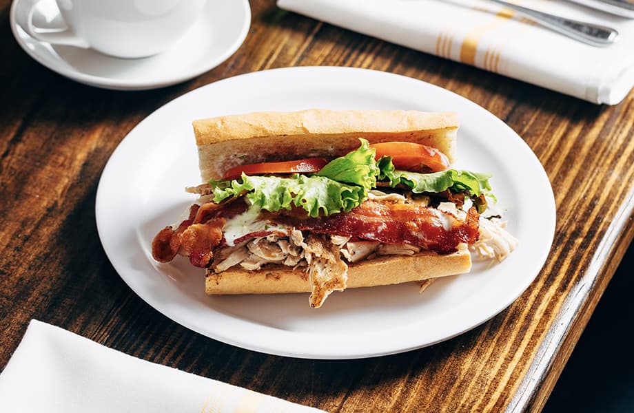 Plate of breakfast with a sandwich and coffee