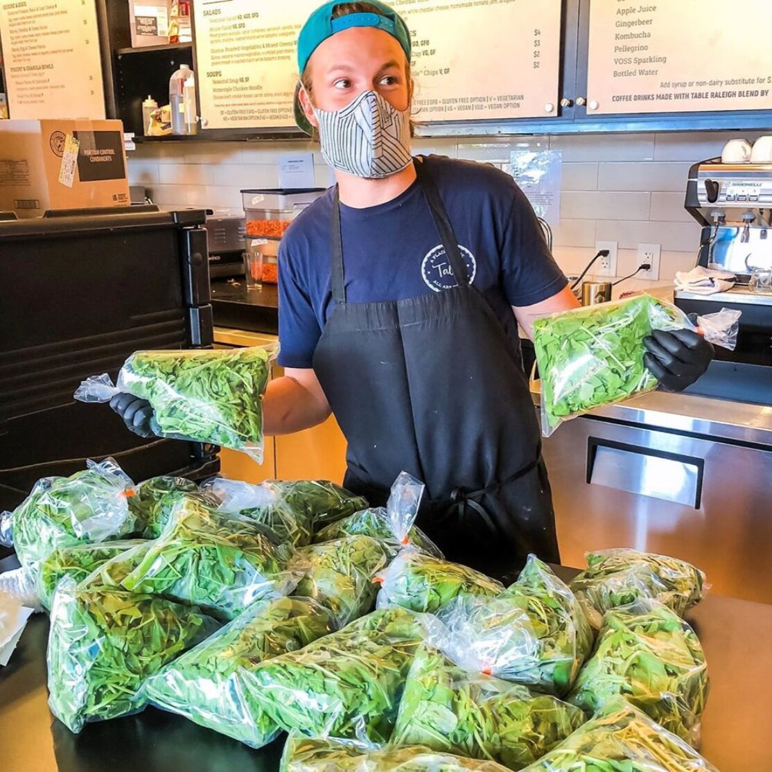 Chef Andrew accepting a produce delivery from Raleigh City Farm